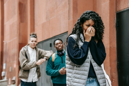 Upset woman crying while two men stand behind her