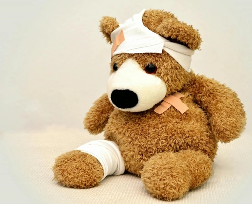 Injured teddy bear with bandages on head, arm and leg