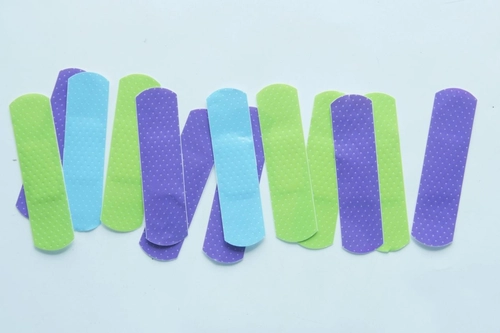 Colorful adhesive bandages in green, blue and purple