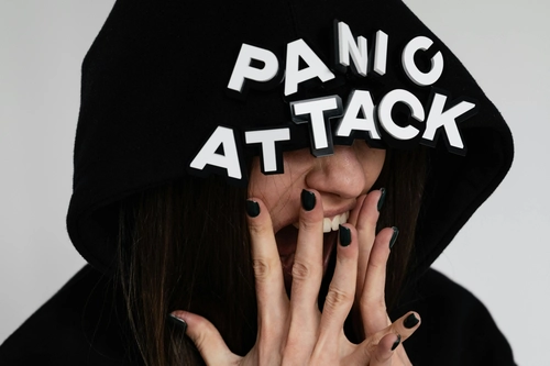 Woman screaming with hands on face suffering from panic attack, 