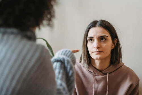 Woman listening calmly as another person talks to her face to face